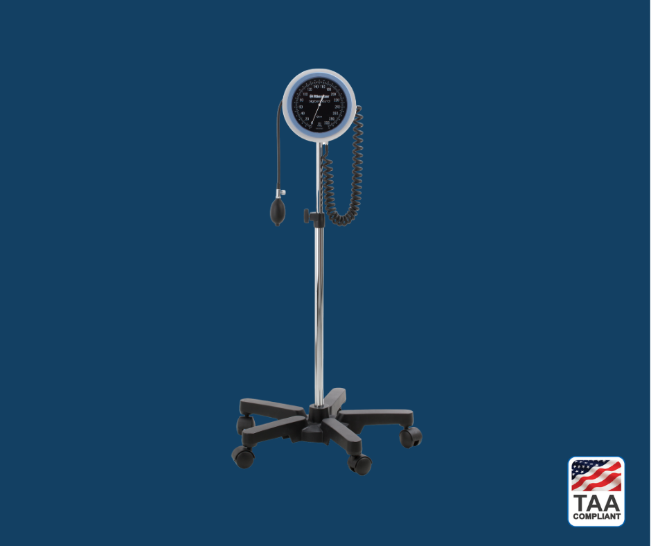 Round stand for Riester Big Ben sphygmomanometer, designed for stable and mobile blood pressure monitoring, placed upright in center of picture with blue background. TAA Compliant symbol with American flag in bottom right-hand corner.