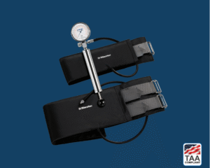 Black Riester komprimeter with circular gauge and latex-free cuff, positioned centrally on blue background; TAA Compliant box featuring American flag in lower right corner.