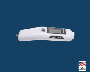 Handheld vital signs monitor placed flat in center of picture with blue background. TAA Compliant symbol with American flag in bottom right-hand corner.